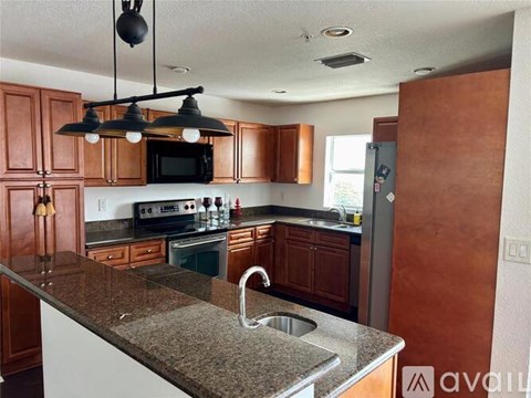 A kitchen with brown cabinets and a granite countertop.