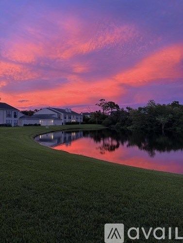 A beautiful sunset view with a lake and buildings in the background.