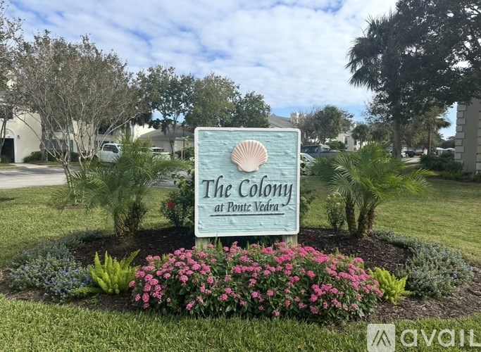 A sign for The Colony at Ponte Vedra surrounded by flowers and plants.