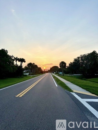 A road with a white line in the middle and trees on both sides.