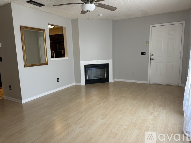 A living room with a fireplace and a ceiling fan.