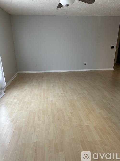 A room with wooden flooring and a ceiling fan.