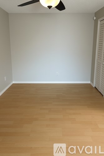 A room with wooden flooring and a ceiling fan.