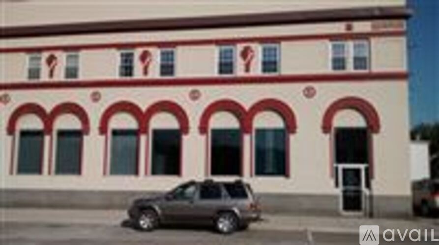 A building with red arches and a car parked in front.