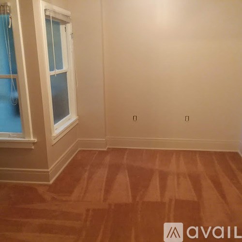 A room with a window and wooden flooring.