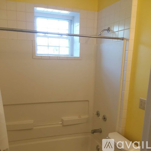 A bathroom with a window in the shower.