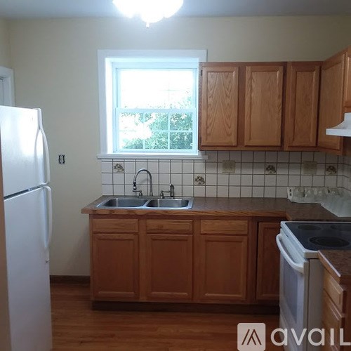 A kitchen with wooden cabinets and a white refrigerator.
