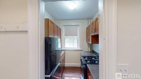 A kitchen with wooden cabinets and a black stove top oven.