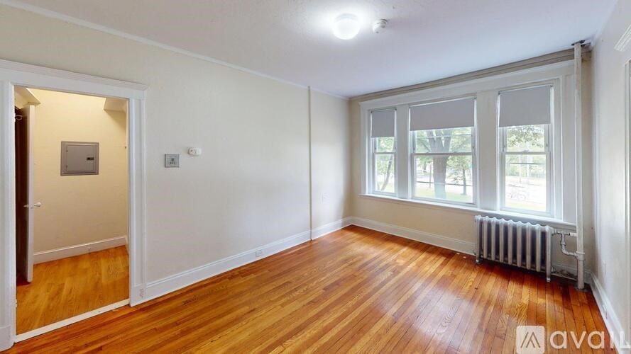 A room with wooden floors and a window with blinds.
