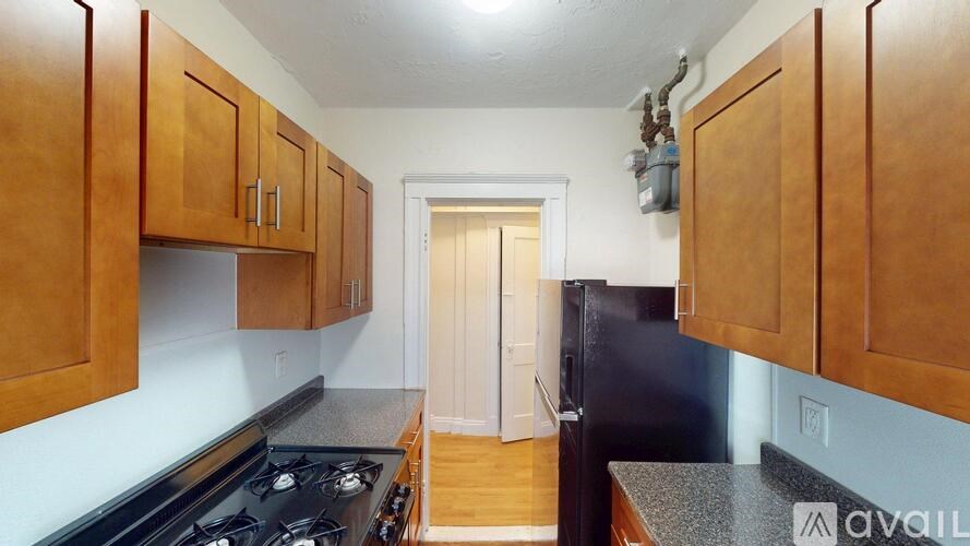 A kitchen with wooden cabinets and a black stove top oven.