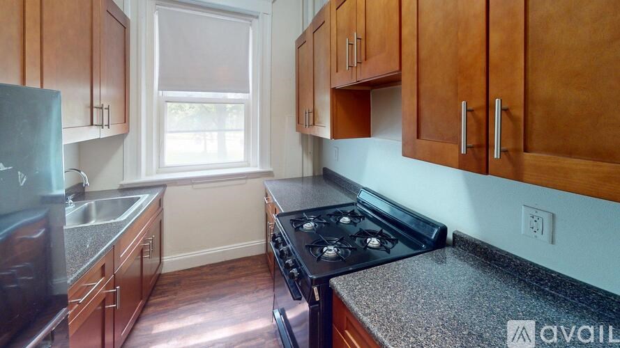 A kitchen with wooden cabinets and a black stove top oven.