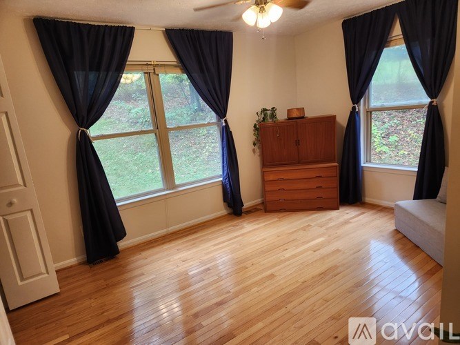 A room with wooden floors and a ceiling fan.
