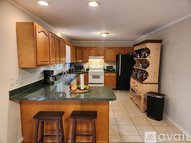 A kitchen with wooden cabinets and a granite countertop.