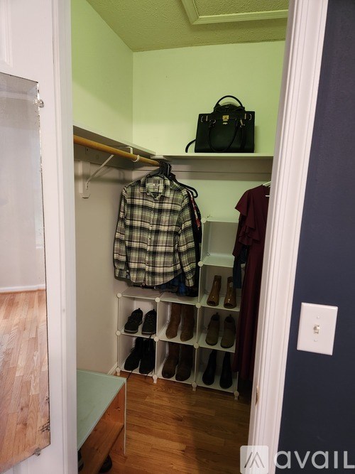 A closet with a plaid shirt hanging on a rod.