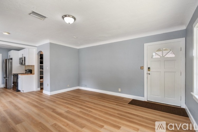 A room with a white door and a brown doormat.