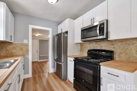A kitchen with a black oven and white cabinets.