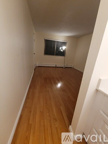 A long hallway with wooden floors and white walls.