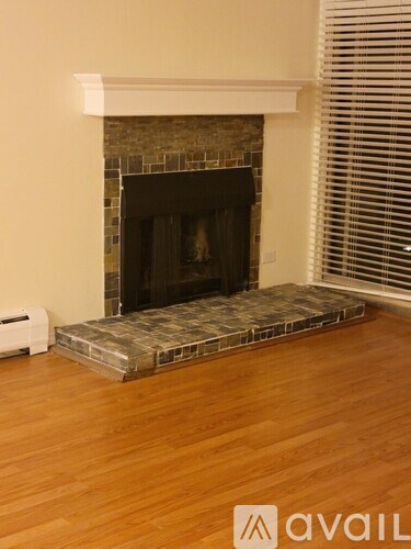 A fireplace with a stone surround and a wooden hearth.