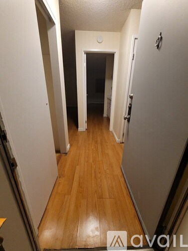A hallway with wood floors and white walls.