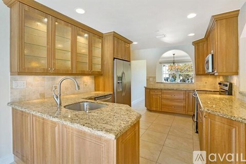 A kitchen with wooden cabinets and granite countertops.