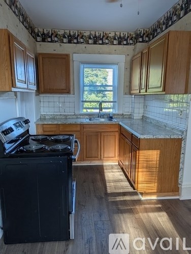 A kitchen with wooden cabinets and a black stove top oven.