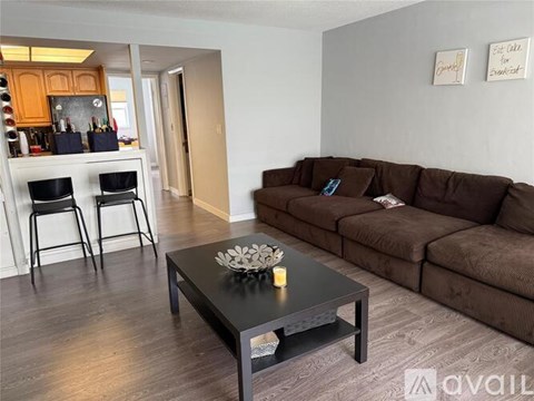 A living room with a brown couch and a black coffee table.