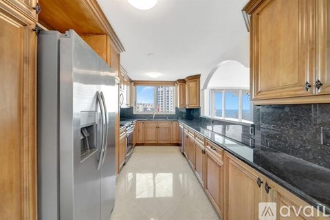 A kitchen with wooden cabinets and a stainless steel refrigerator.