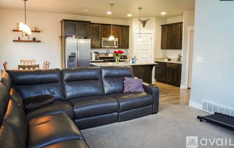 A black leather couch in a well-lit living room.