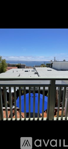 A blue pool is surrounded by a white fence.