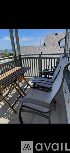 A wooden table and chairs are on a patio.