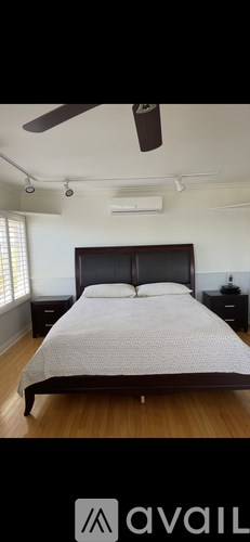 A bedroom with a large bed and a ceiling fan.
