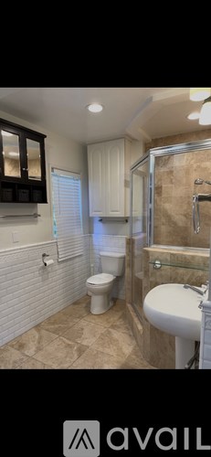 A bathroom with a toilet, sink, and shower.