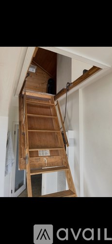 A wooden staircase with a metal handrail is partially open.