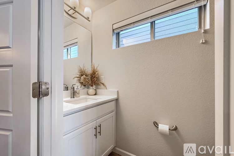 A bathroom with a white sink and a mirror.
