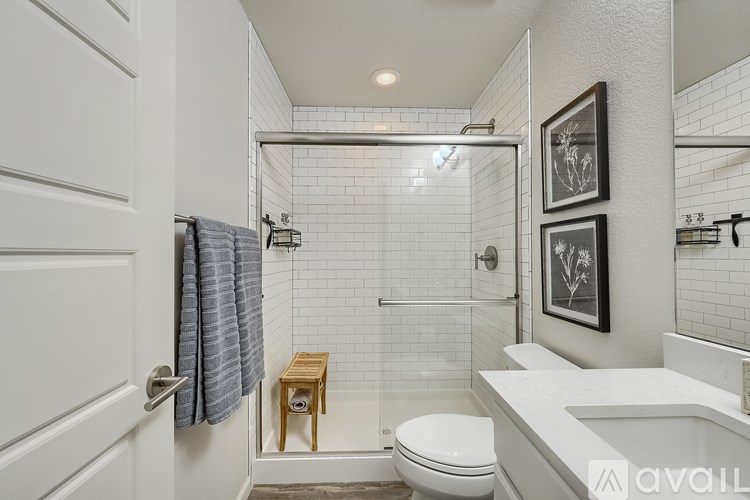 A bathroom with a toilet, a shower, and a sink.