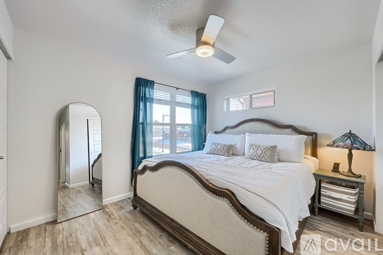 A bedroom with a large bed and a ceiling fan.