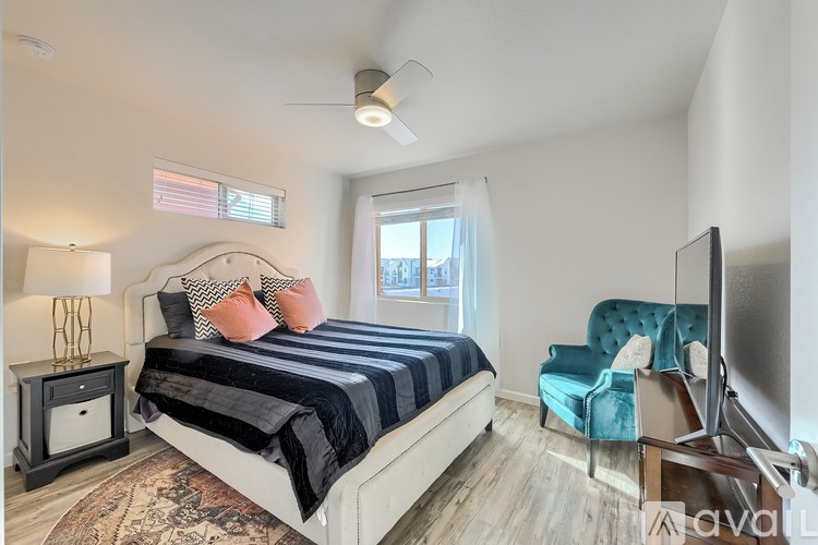 A bedroom with a bed, chair, and television.