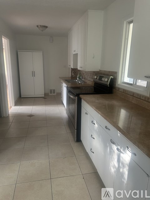 A kitchen with white cabinets and a brown countertop.