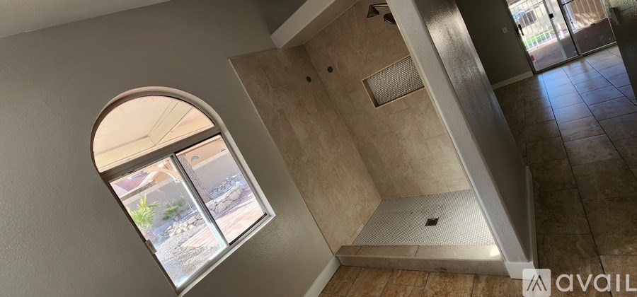 A bathroom with a window and a shower.