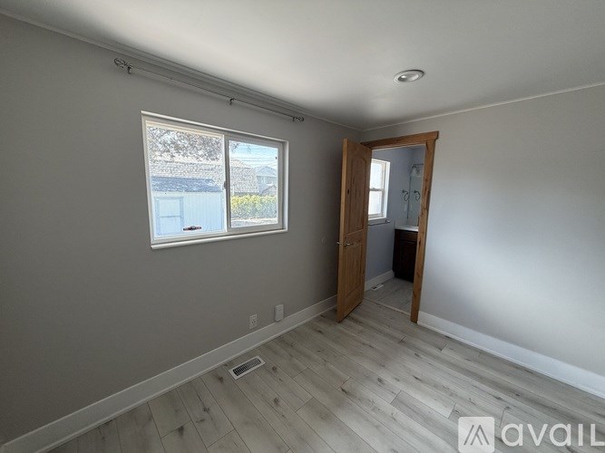 A room with a window and a door leading to another room.