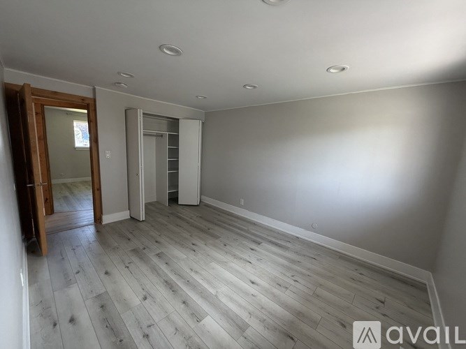 A room with wooden flooring and white walls.
