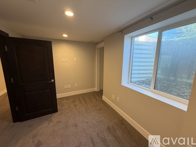 A room with a door, window, and carpeted floor.