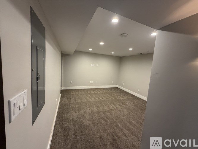 A room with a carpeted floor and a white ceiling with lights.