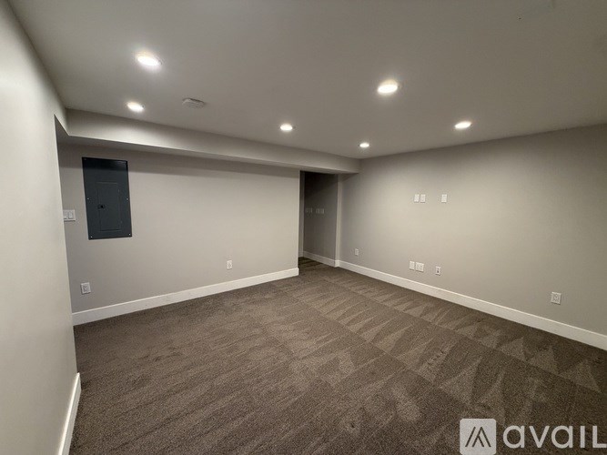 A room with carpeted flooring and a door on the left.