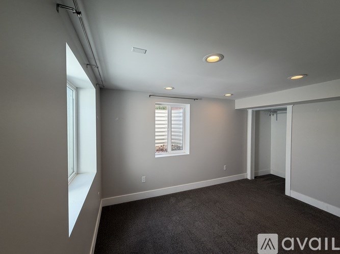 A room with a window and a door is available for rent.