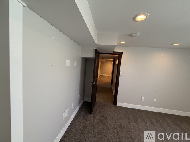 A room with a carpeted floor and a doorway leading to another room.