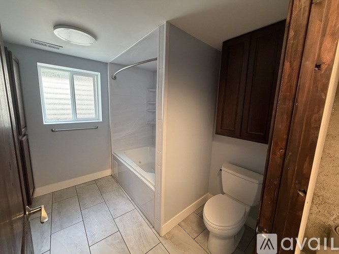 A small bathroom with a toilet, tub, and shower.