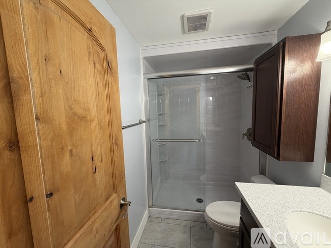 A bathroom with a toilet, sink, and shower.