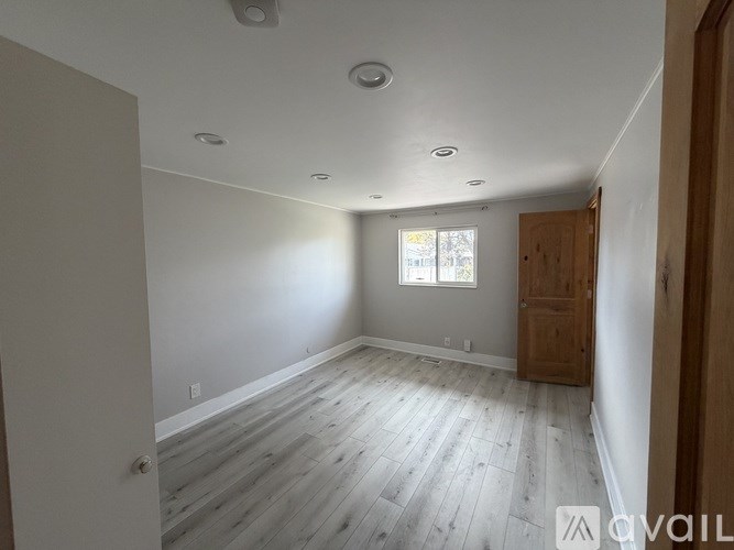 A room with wooden flooring and a window.