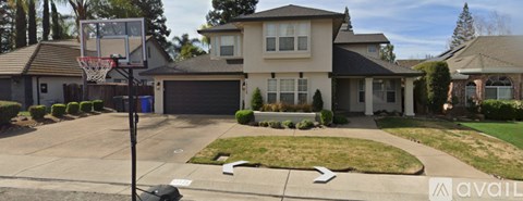 A house with a basketball hoop in the driveway.